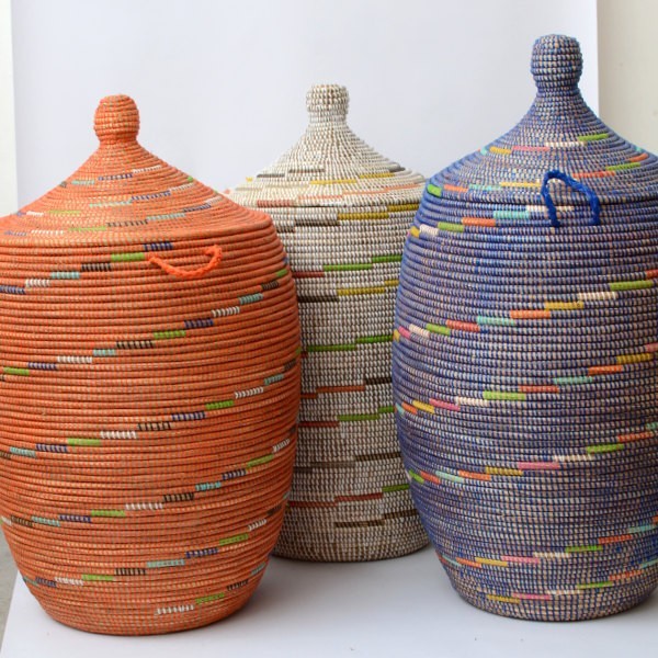 Wäschekorb aus dem Senegal, aus Gras und bunten Plastikbändern.
